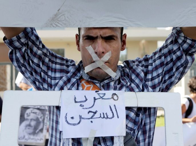 A relative of the leaders of Morocco's Hirak protest movement displays a placard that reads
