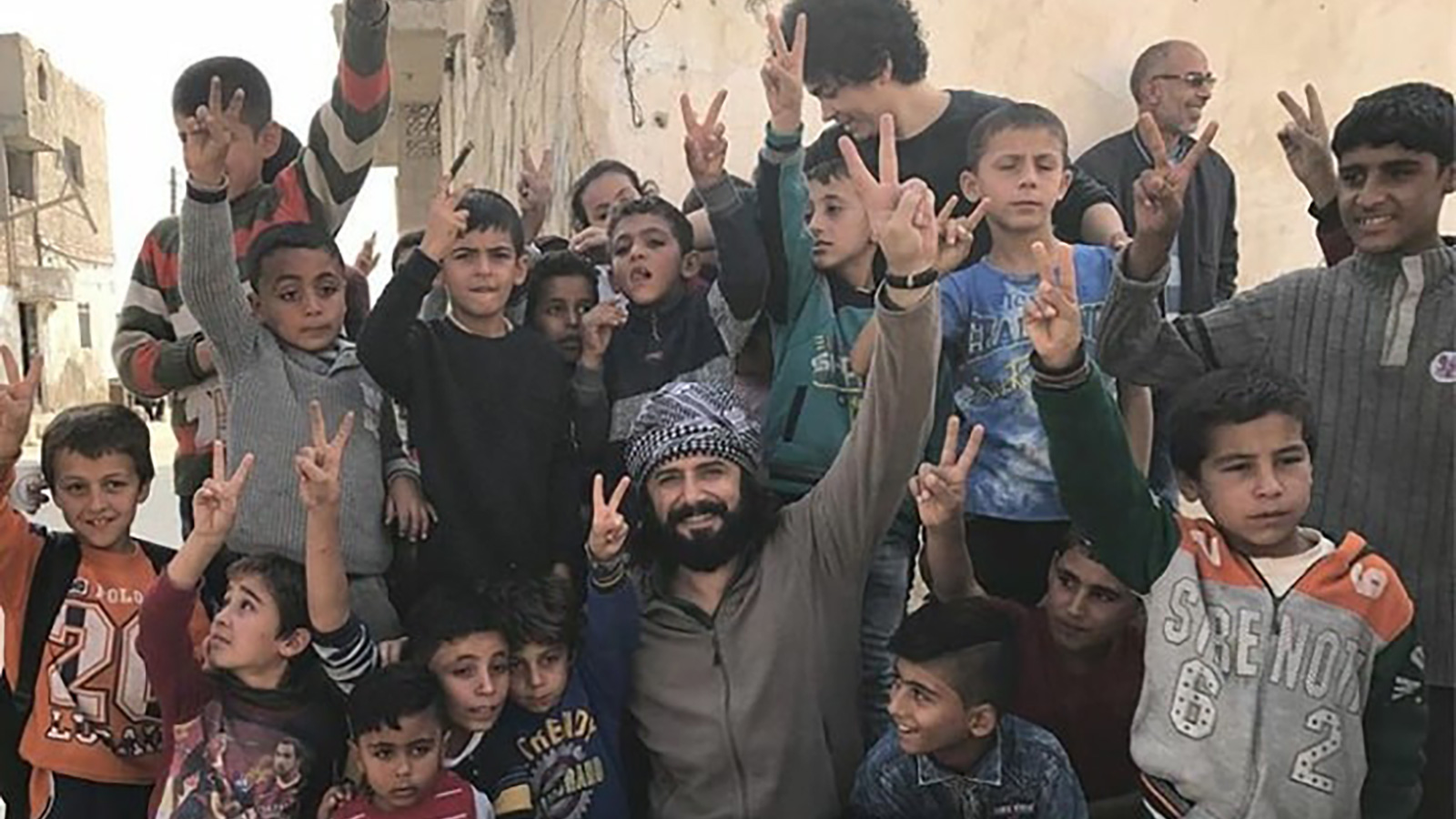 ‪النجم التركي جيم أوتشان يتوسط مجموعة من الأطفال السوريين خلال تصوير الفيلم‬ النجم التركي جيم أوتشان يتوسط مجموعة من الأطفال السوريين خلال تصوير الفيلم (الجزيرة)