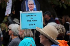 A demonstrator holds a sign in support of U.S. special prosecutor Robert Mueller as she attends a protest against U.S. President Donald Trump and Republican congressman Darrell Issa (R-Vista) outside Issa's office in Vista, California, U.S., October 31, 2017. REUTERS/Mike Blake