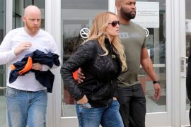 Adult film star Stormy Daniels, whose real name is Stephanie Clifford, and her security leave the Detroit Police Department 4th Precinct after picking up her temporary Dance Permit license to perform at a club in Detroit, Michigan, U.S., April 18, 2018. REUTERS/Rebecca Cook
