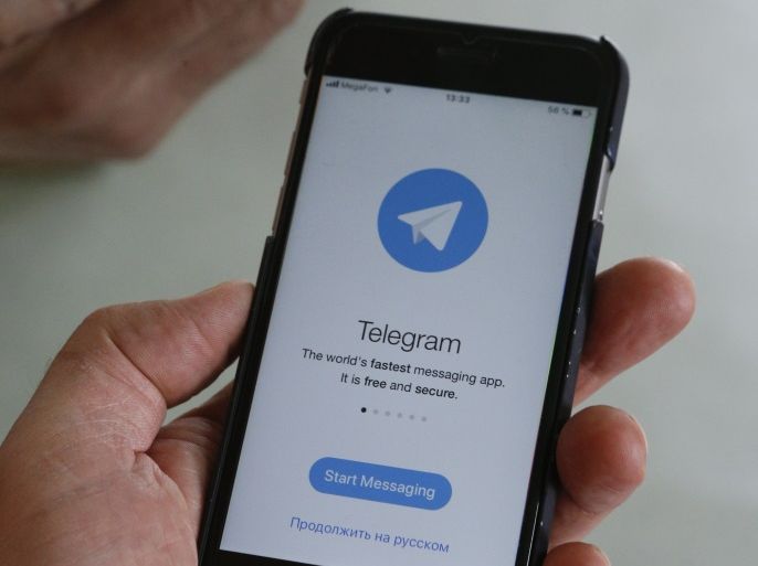 People pose with smartphones, with the Telegram logo seen on a screen, in this picture illustration taken April 13, 2018. REUTERS/Eduard Korniyenko
