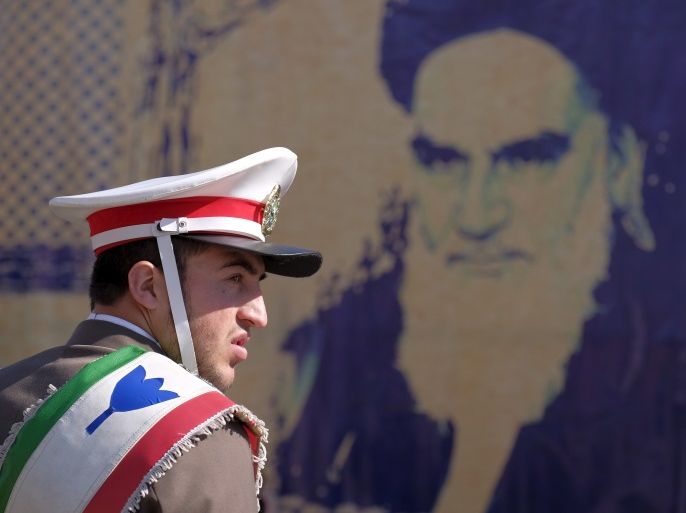 An Iranian soldier stands guard in front of a picture of Iran's late leader Ayatollah Ruhollah Khomeini during the anniversary ceremony of Iran's Islamic Revolution in Behesht Zahra cemetery, south of Tehran, February 1, 2016. REUTERS/Raheb Homavandi/TIMA ATTENTION EDITORS - THIS IMAGE WAS PROVIDED BY A THIRD PARTY. FOR EDITORIAL USE ONLY.