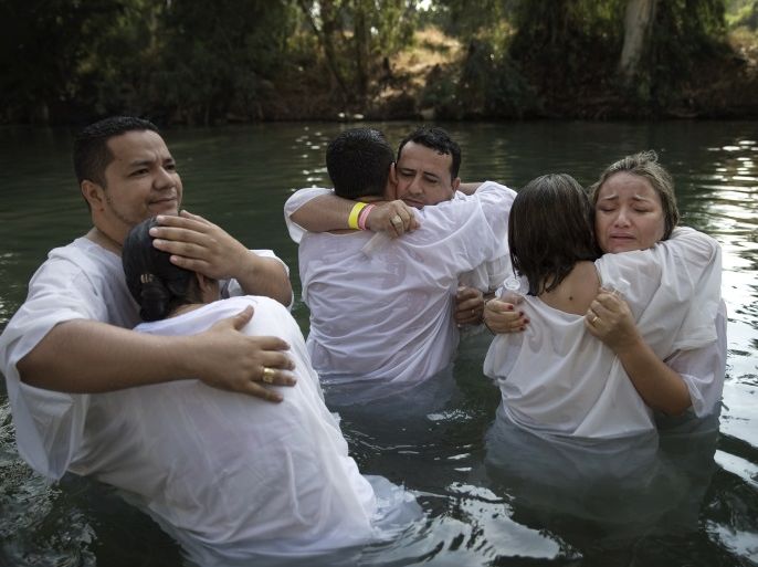 Christian pilgrims from Brazil embrace after they are baptized in the water of the Jordan River during a ceremony at the Yardenit baptismal site near the northern Israeli city of Tiberias October 15, 2014. Yardenit is one of the sites along the Jordan River where it is believed Jesus was baptized. REUTERS/Finbarr O'Reilly (ISRAEL - Tags: RELIGION TRAVEL)