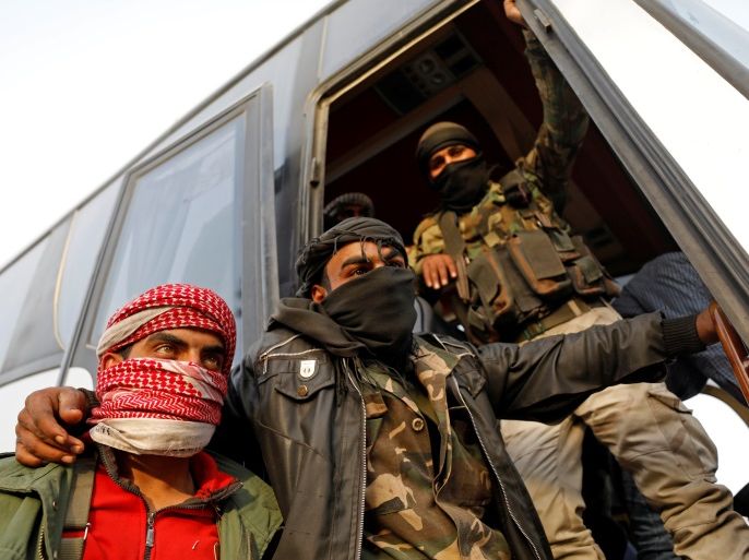 Rebel fighters gesture as they stand next to a bus before their evacuation, at Harasta highway outside Jobar, in Damascus, Syria March 26, 2018. REUTERS/Omar Sanadiki