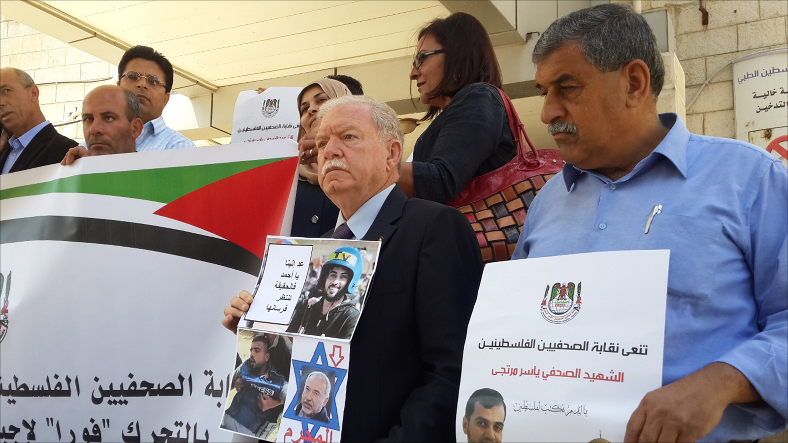 ‪‬ فلسطينيون يحملون صور الصحفييْن ياسر مرتجى وأحمد أبو حسين اللذين استشهدا برصاص الاحتلال خلال تغطيتهما مسيرات العودة على حدود غزة(الجزيرة)