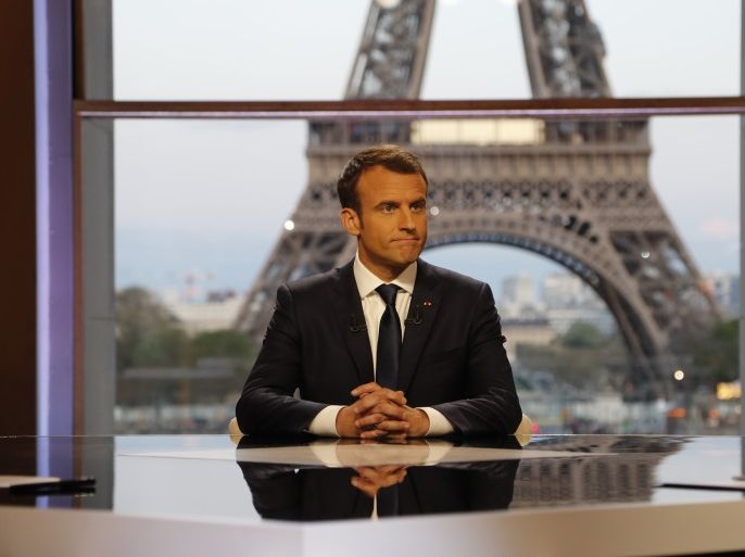 French President Emmanuel Macron poses on the TV set before an interview with RMC-BFM and Mediapart French journalists at the Theatre National de Chaillot in Paris, France, April 15, 2018. Francois Guillot/Pool via Reuters