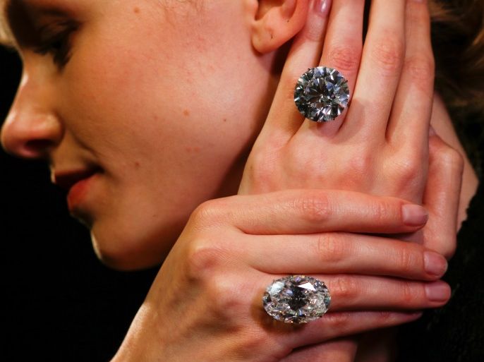 A model poses with two white diamonds, each over 50 carats, at Sotheby's auction house in London, Britain, April 6, 2018. REUTERS/Henry Nicholls