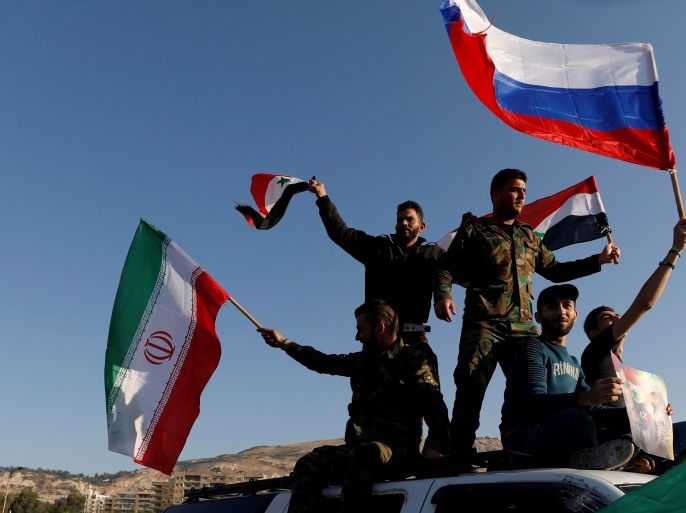 Syrians wave Iranian, Russian and Syrian flags during a protest against U.S.-led air strikes in Damascus,Syria April 14,2018.REUTERS/ Omar Sanadiki TPX IMAGES OF THE DAY