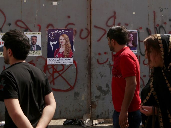 epa06670746 Kurdish people walk past campaign posters of Kurdish candidates to Iraqi parliamentary elections, in Erbil, Kurdistan Region, Iraq, 15 April 2018. Campaigning for the 12 May parliamentary elections started in the Kurdistan Region on 15 April, one day after it began in other part of the county, as the region was observing the 30th anniversary of Anfal campaign that was conducted against Kurds. EPA-EFE/GAILAN HAJI