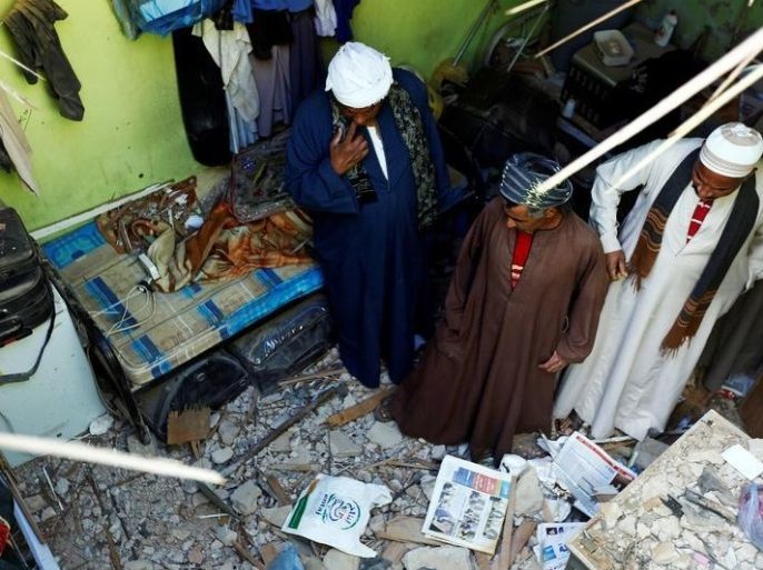 أشخاص يتفقدون الأضرار التي خلفتها شظايا، ناتجة عن صواريخ بالستية أطلقها الحوثيون في اليمن، سقطت على منزل في الرياض، السعودية، 26 مارس/آذار 2018.