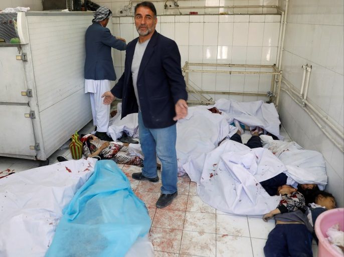 ATTENTION EDITORS - VISUAL COVERAGE OF SCENES OF INJURY OR DEATH A man reacts as he stands among dead bodies at a hospital after a suicide attack in Kabul, Afghanistan April 22, 2018.REUTERS/Mohammad Ismail TEMPLATE OUT