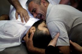 ATTENTION EDITORS - VISUAL COVERAGE OF SCENES OF INJURY OR DEATH The brother of Palestinian Shaher al-Madhoon, who was killed during a protest at the Israel-Gaza border, reacts over his body at a hospital morgue in the northern Gaza Strip May 14, 2018. REUTERS/Mohammed Salem TEMPLATE OUT TPX IMAGES OF THE DAY