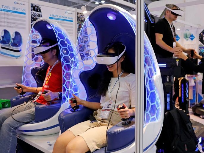 Visitors try Chinese made virtual reality (VR) goggles during Global Sources Mobile Electronics show, in Hong Kong, China April 18, 2018. REUTERS/Tyrone Siu