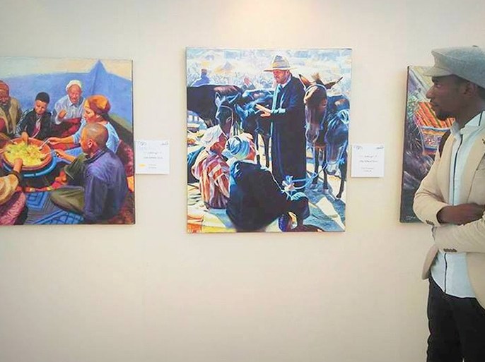 الفنان التشكيلي الجزائري بابي عبد الغاني أمام لوحات تشكيلية في اول سوق للفن بالجزائر تصوير ياسين بودهان الجزيرة نت