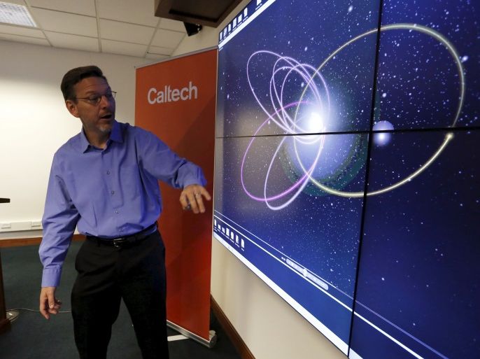 Professor of Planetary Astronomy Mike Brown speaks in front of a computer simulation of the probable orbit of Planet Nine (yellow) at the California Institute of Technology in Pasadena, California January 20, 2016. The solar system may host a ninth planet that is about 10 times bigger than Earth and orbiting far beyond Neptune, according to research published on Wednesday. REUTERS/Mario Anzuoni