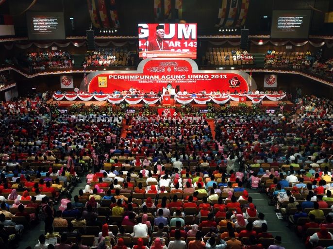 Members of the United Malays National Organisation (UMNO) watch as Malaysia's Prime Minister Najib Razak is seen on a giant screen as he delivers a speech during the annual UMNO assembly in Kuala Lumpur December 5, 2013. The annual UMNO assembly will be held from December 4 to 7. REUTERS/Samsul Said (MALAYSIA - Tags: POLITICS)