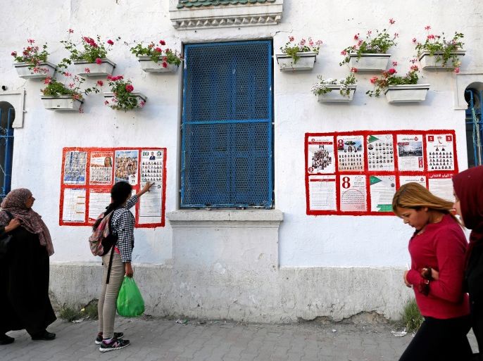People walk past posters for the municipal elections in Tunis, Tunisia April 27, 2018. Picture taken April 27, 2018. REUTERS/Zoubeir Souissi