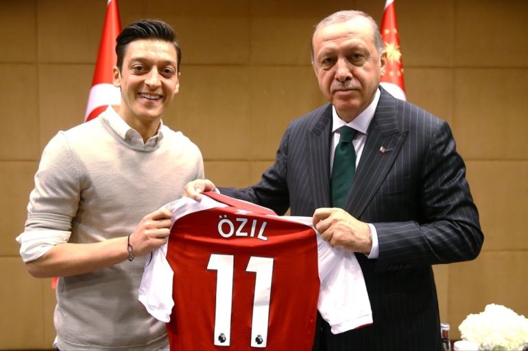LONDON, UNITED KINGDOM - MAY 13: Turkish-German football player Mesut Ozil who plays for Arsenal (L) presents a jersey to Turkish President Recep Tayyip Erdogan before their meeting in London, United Kingdom on May 13, 2018.