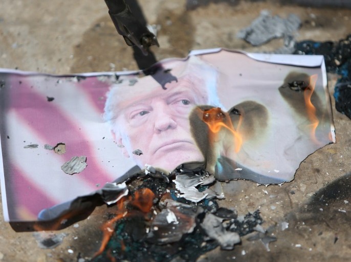 Palestinians burn a picture of President Donald Trump during a sit-in inside the Ain el-Hilweh refugee camp near Sidon, southern Lebanon, May 14, 2018. REUTERS/Ali Hashisho