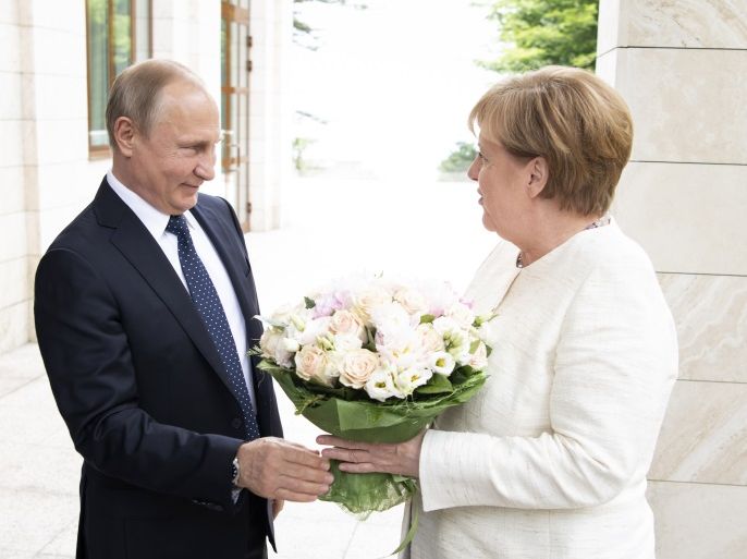 SOTSCHI, RUSSIA - MAY 18: In this handout photo provided by the German Government Press Office (BPA), German Chancellor Angela Merkel is handed over a bouquet of flowers as she meets Russian President Vladimir Putin in his residency on May 18, 2018 in Sotschi, Russia. (Photo by Guido Bergmann/Bundesregierung via Getty Images)