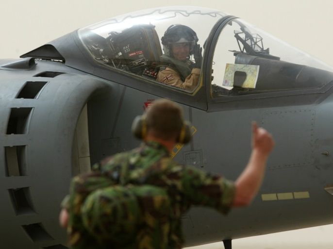 British Royal Air Force ground crewman Warrent Officer Walter Murtonwaves as a British Joint Harrier Force Harrier GR7 plane taxis out tothe runway before a mission, at their base in Kuwait March 27, 2003.Britain said on Thursday is was almost certain that two dead soldierswhose bodies were shown on Qatar-based al-Jazeera television wereindeed British, as the station claimed. REUTERS/Russell BoyceRUS/CRB