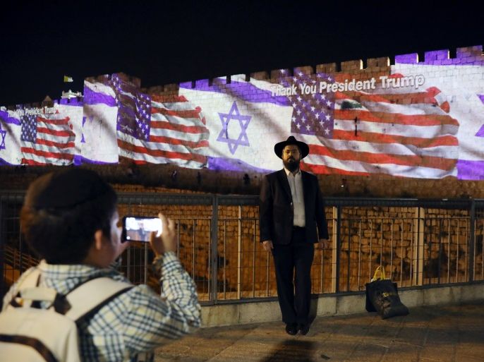 People take pictures of the U.S. and Israeli national flags as projected on a part of the walls surrounding Jerusalem's Old City May 14, 2018. REUTERS/Ammar Awad TPX IMAGES OF THE DAY