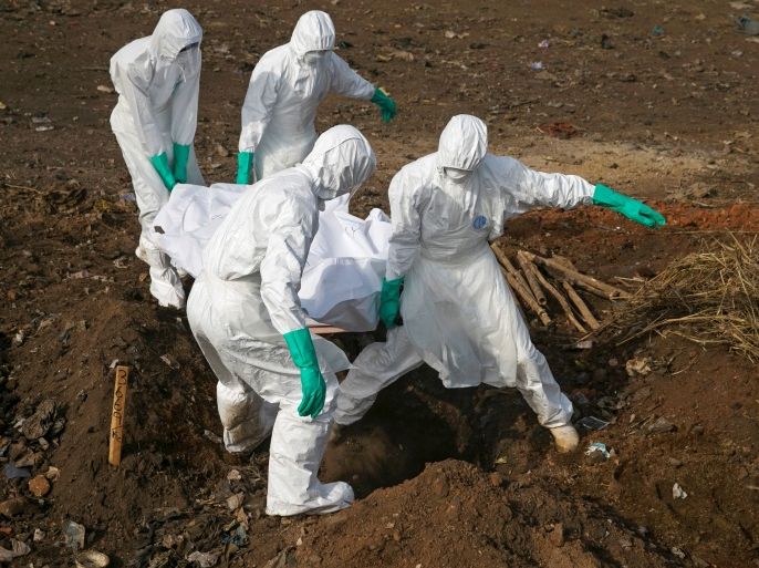 Health workers carry the body of a suspected Ebola victim for burial at a cemetery in Freetown, Sierra Leone, December 21, 2014. To match Special Report HEALTH-WHO/LEADER REUTERS/Baz Ratner/File Photo