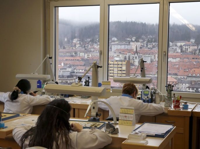 FILE PHOTO: Women work at their desk in a workshop of independent dial supplier Singer, overlooking the city of La Chaux-de-Fonds, Switzerland, April 7, 2016. The sites of La Chaux-de-Fonds and Le Locle are listed in the UNESCO World Heritage for their watchmaking town-planning. REUTERS/Denis Balibouse/File Photo