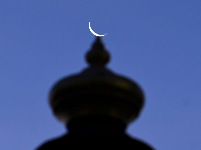 A crescent moon is pictured on top of the Sultan Ismail Petra Arch, a landmark of Kota Bharu in Kelantan, Malaysia April 13, 2018. Picture taken April 13, 2018. REUTERS/Stringer