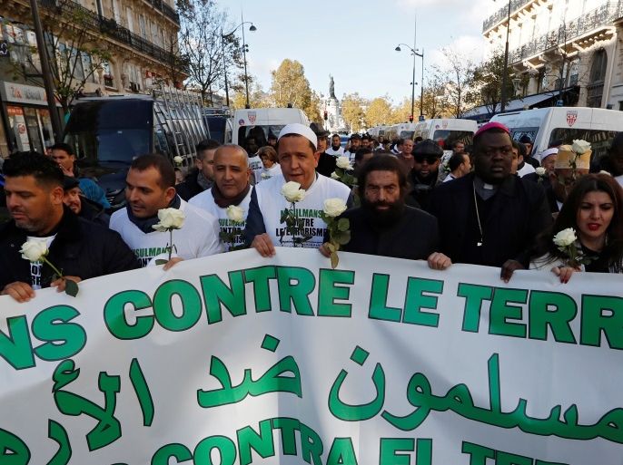 Imam Hassen Chalghoumi (4thL) and French author Marek Halter (C) walk behind a banner that reads