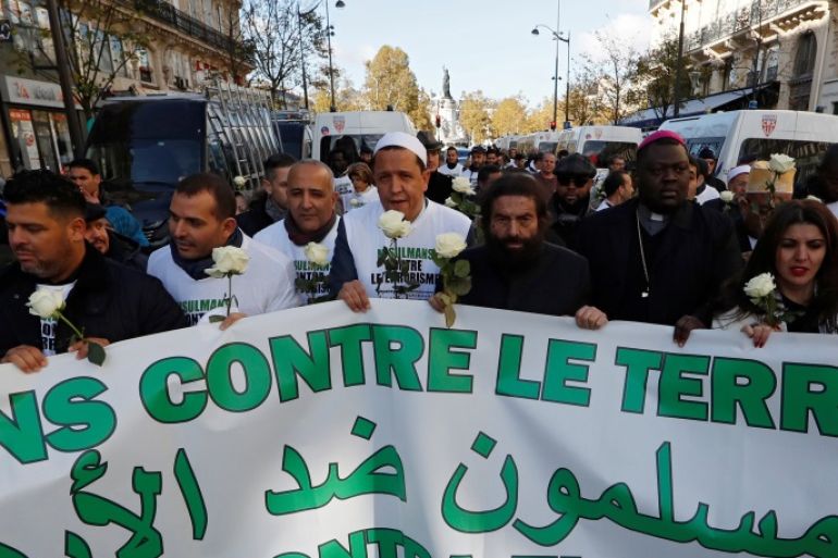 Imam Hassen Chalghoumi (4thL) and French author Marek Halter (C) walk behind a banner that reads