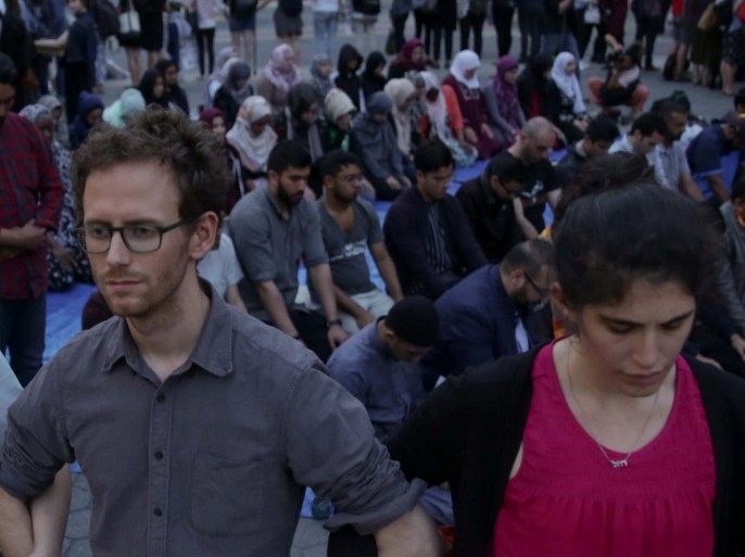 Protesters form a human chain as Muslims offer