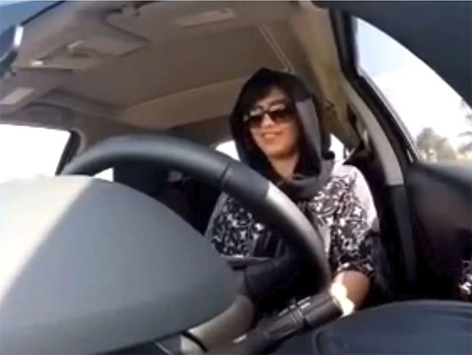 ‪الهذلول وهي تقود سيارتها من الإمارات إلى السعودية‬ عام 2014 وهو ما عرّضها للسجن