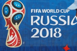 Soccer Football - FIFA World Cup - Saint Petersburg Stadium, St. Petersburg, Russia - June 11, 2018. A man is seen next to the FIFA World Cup logo at the stadium. REUTERS/Fabrizio Bensch