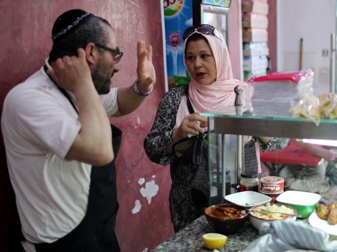 A Tunisian Muslim woman buy food from a Jewish restaurant in Djerba, Tunisia May 1, 2018. Picture taken May 1, 2018. REUTERS/Ahmed Jadallah