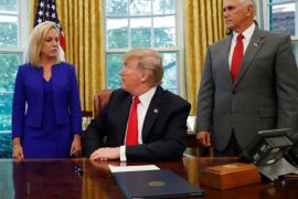 U.S. President Donald Trump looks back at DHS Secretary Kirstjen Nielsen as he prepares to sign an executive order on immigration policy with Vice President Mike Pence at his side in the Oval Office at the White House in Washington, U.S., June 20, 2018. REUTERS/Leah Millis