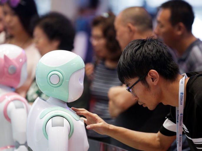 A man programs an iPal Companion Robot by Nanjing Avatar Mind Robot Technology at the 2017 World Robot conference in Beijing, China August 22, 2017. REUTERS/Thomas Peter