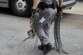A man carries shackles that are to be put on undocumented immigrants outside a U.S. federal court in McAllen, Texas, U.S., June 25, 2018. REUTERS/Loren Elliott