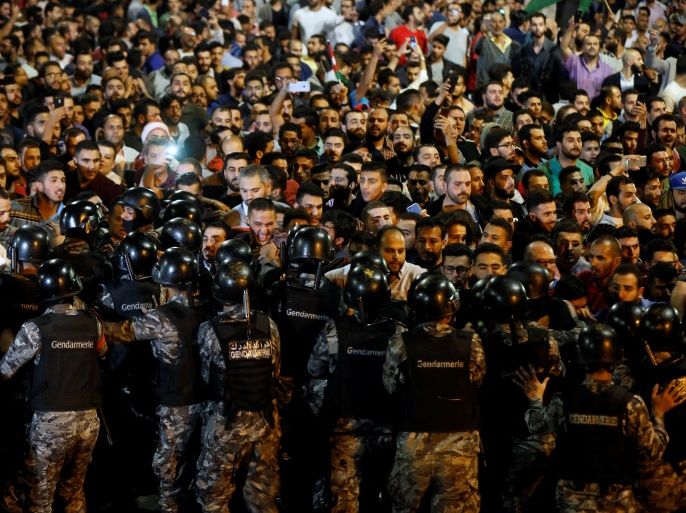 Demonstrators stand face to face with riot police during a protest in front of the Prime Minister's office in Amman, Jordan June 1, 2018. REUTERS/Muhammad Hamed