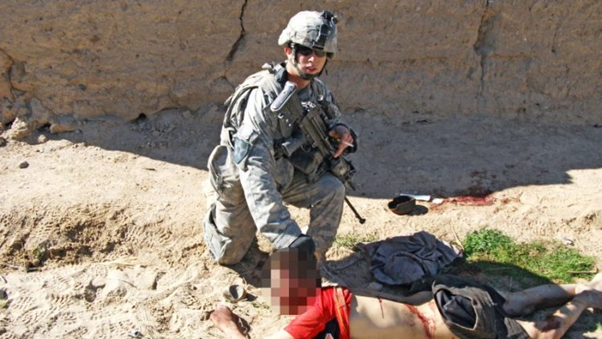 جندي أمريكي يلتقط صورة تذكارية مع قتيل أفغاني