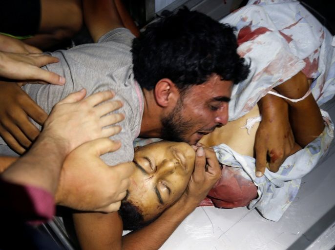 ATTENTION EDITORS - VISUAL COVERAGE OF SCENES OF INJURY OR DEATH The brother of a Palestinian teenager who was killed in an Israeli air strike, reacts over his body in Gaza City July 14, 2018. REUTERS/Mohammed Salem TEMPLATE OUT