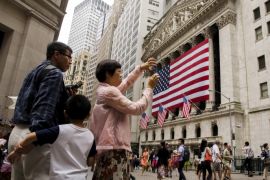 Chinese tourists take photographs outside of the New York Stock Exchange shortly after the opening bell in New York, July 8, 2015. REUTERS/Lucas Jackson
