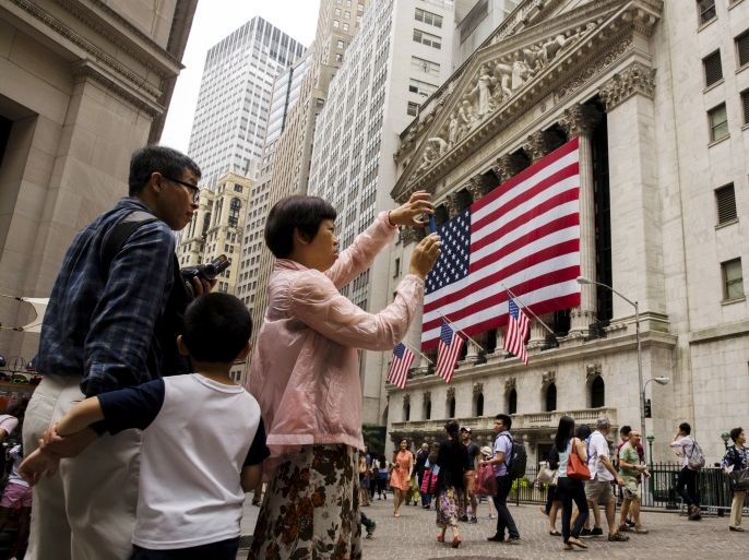 Chinese tourists take photographs outside of the New York Stock Exchange shortly after the opening bell in New York, July 8, 2015. REUTERS/Lucas Jackson