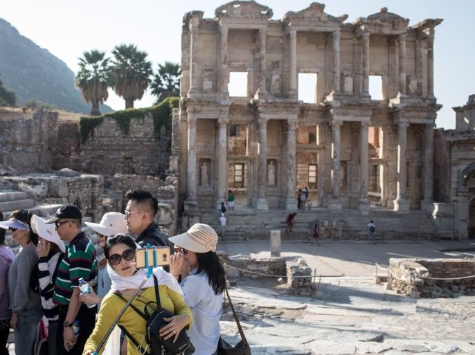 IZMIR, TURKEY - SEPTEMBER 18: A member of an asian tourist group takes a selfie in front of the ruins of the Library of Celsus in the ancient city of Ephesus on September 18, 2017 in Izmir, Turkey. The ancient city of Ephesus continues to draw visitors as one of Turkey's top tourist attractions. Ephesus was an Ancient Greek city. Excavations of the site have revealed grand monuments from the Roman Imperial period including the remains of the famous Temple of Artemis, the Great Theatre and the Library of Celsus. (Photo by Chris McGrath/Getty Images)