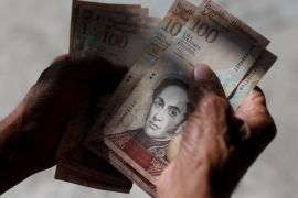 A man counts Venezuelan bolivar notes in downtown Caracas, Venezuela January 9, 2018. REUTERS/Marco Bello
