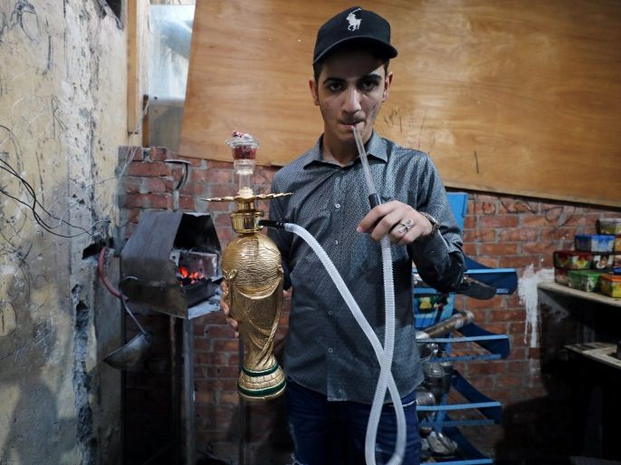 A cafe worker prepares and smokes a shisha shaped as World Cup trophy replica at a cafe in Cairo, Egypt July 4, 2018. Picture taken July 4, 2018. REUTERS/Mohamed Abd El Ghany