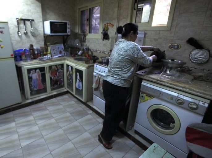 Nahed, or "Um Rania", 52, prepares lunch in her kitchen at her home after she finished a shift driving a minibus in Cairo's Al Moqattam district March 4, 2014. Nahed, a widow whose husband died 21 years ago, bought a minibus and learned to drive after her street vending business failed. A supporter of Army Chief Field Marshal Abdel Fattah al-Sisi, she hopes the government can return stability to the country without any further violence. On March 8 activists around the