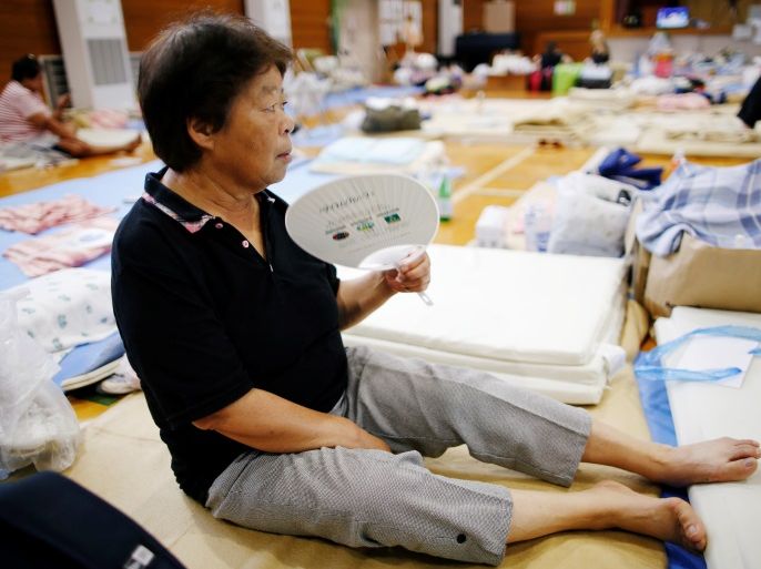 An evacuee uses paper fan as she takes a rest at Okada elementary school that is used as an evacuation center in Mabi town in Kurashiki, Okayama Prefecture, Japan July 12, 2018. REUTERS/Issei Kato