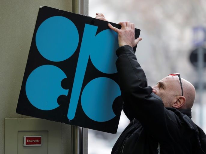 A man fixes a sign with OPEC's logo next to its headquarter's entrance before a meeting of OPEC oil ministers in Vienna, Austria, November 29, 2017. REUTERS/Heinz-Peter Bader