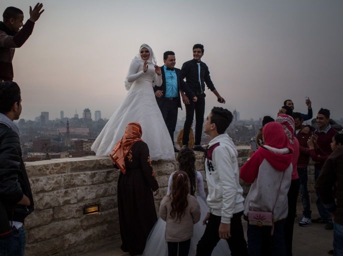 CAIRO, EGYPT - DECEMBER 10: A newlywed couple pose for wedding photos on a wall in a park overlooking Cairo on December 10, 2016 in Cairo, Egypt. Since the 2011 Arab Spring, Egyptians have been facing a crisis, the uprising brought numerous political changes, but also economic turmoil, increased terror attacks and the unravelling of the once strong tourism sector. In recent weeks Egypt has again been hit by multiple bomb blasts, the most recent killed 26 Christians insi